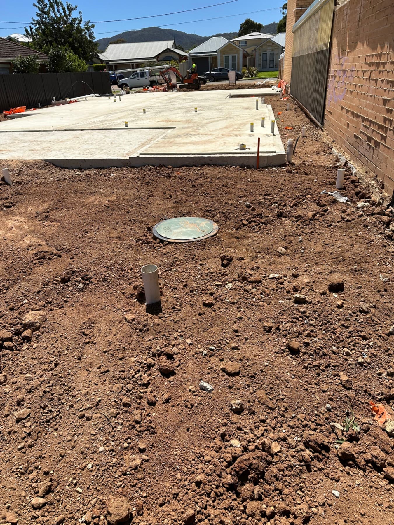 Concrete slab with flush inspection lid over a completed underground tank installation