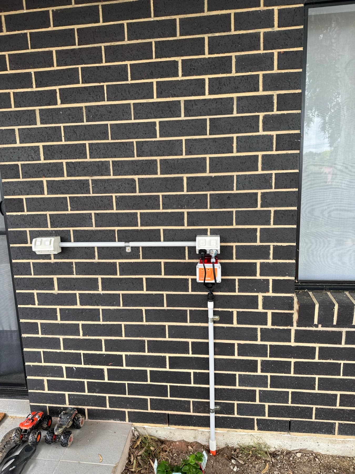 Electrical isolation switches and pump alarm wiring mounted on a brick wall