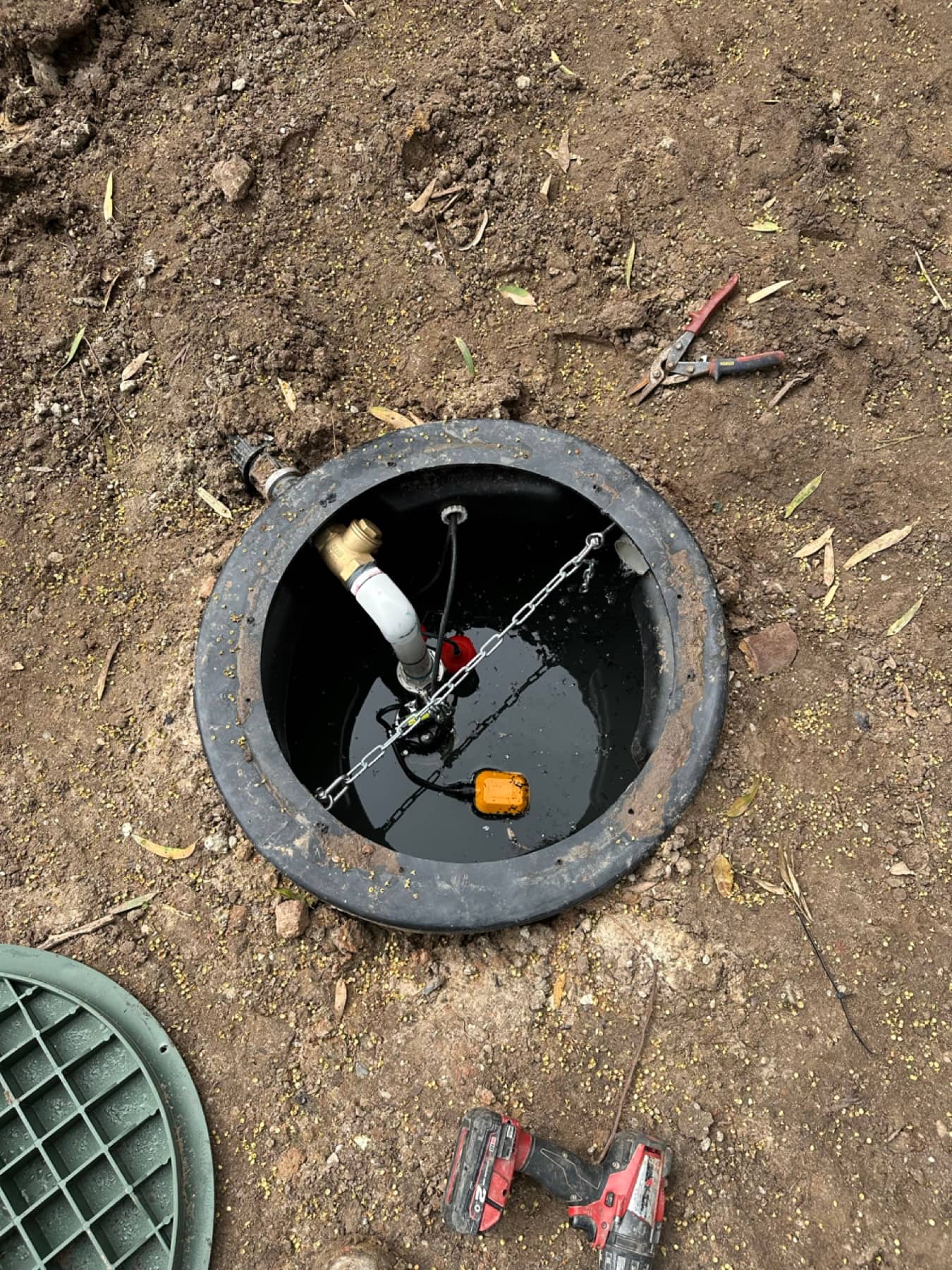 Sump pump installation with power connection and safety alarm